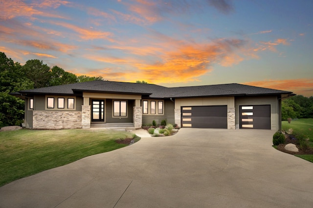 prairie-style home with a garage and a yard