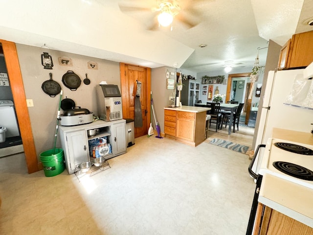 kitchen featuring white appliances, kitchen peninsula, washer / clothes dryer, and ceiling fan