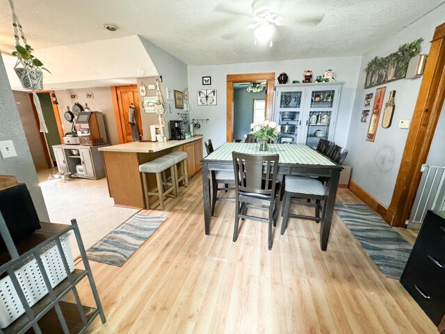 dining room featuring a textured ceiling, ceiling fan, and light hardwood / wood-style flooring