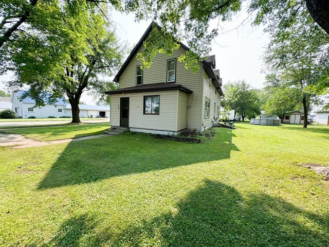 view of front of home featuring a shed and a front yard