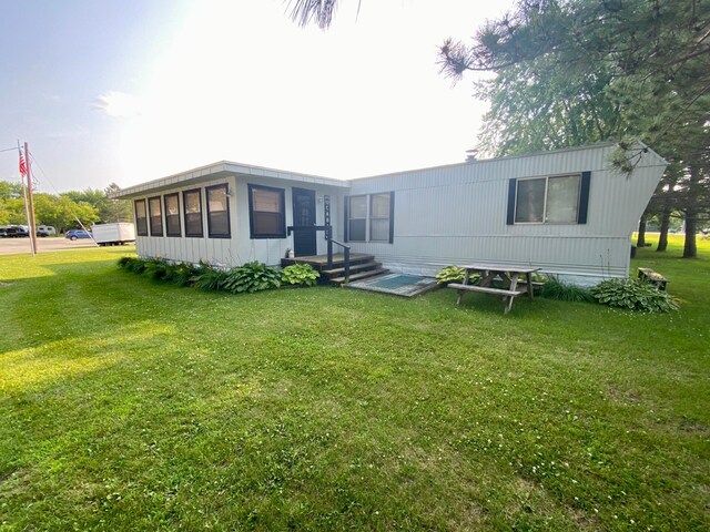 rear view of house featuring a yard