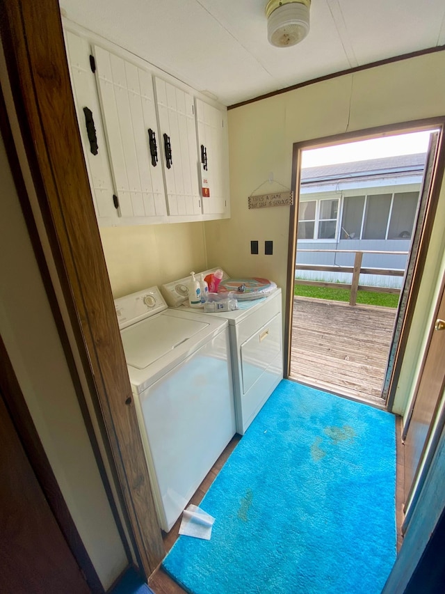 laundry room featuring cabinets, wood-type flooring, and independent washer and dryer