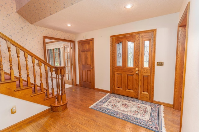 foyer featuring light hardwood / wood-style floors and a textured ceiling