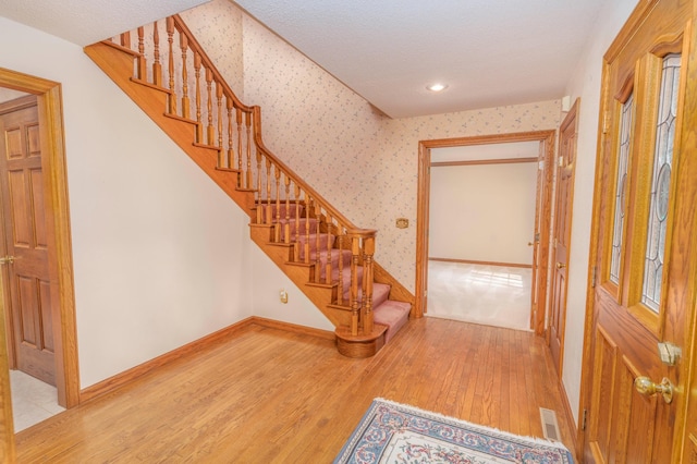 stairway featuring hardwood / wood-style floors and a textured ceiling