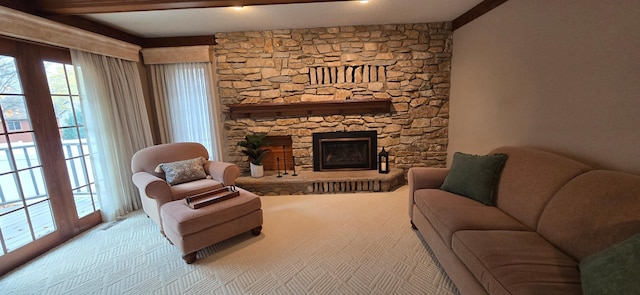 carpeted living room featuring beam ceiling and a stone fireplace