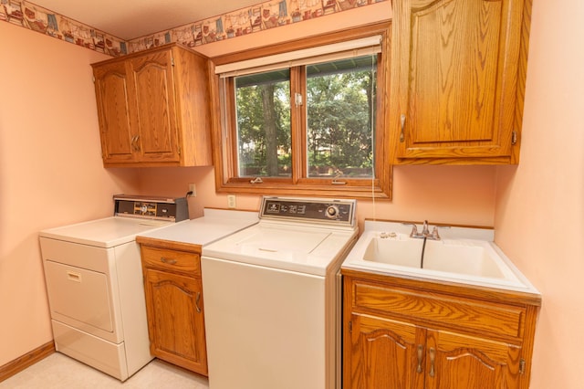 laundry area with cabinets, separate washer and dryer, and sink