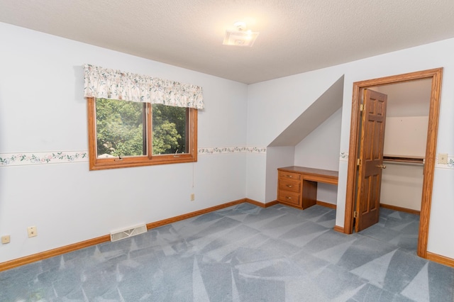 additional living space with a textured ceiling and light carpet