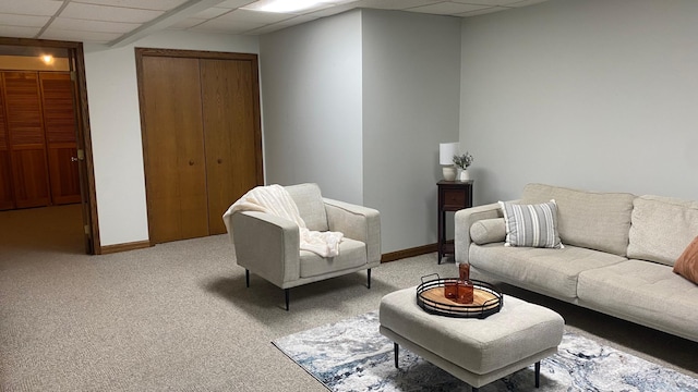 carpeted living room featuring a paneled ceiling