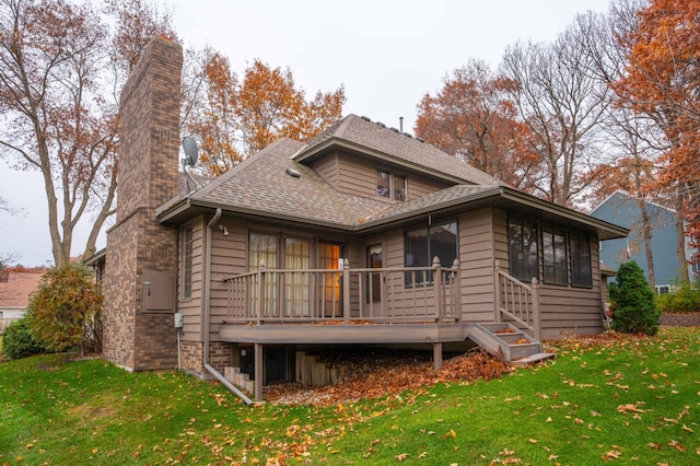 back of property featuring a wooden deck and a yard