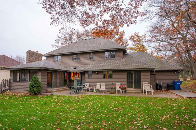 back of property with a lawn and a patio