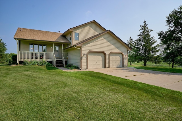 split level home featuring covered porch, a garage, a front yard, concrete driveway, and a shingled roof