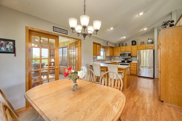 dining space featuring light wood-type flooring, a chandelier, vaulted ceiling, and recessed lighting
