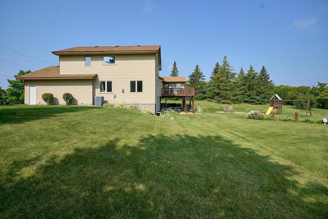 rear view of house featuring central AC unit, a yard, a playground, and a wooden deck