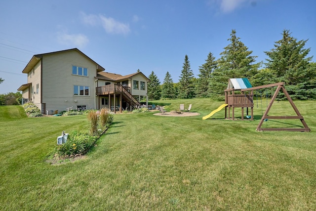 view of grassy yard with a playground and a wooden deck