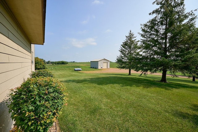 view of green lawn with an outdoor structure and a garage