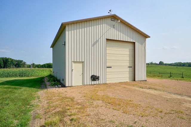 view of outdoor structure featuring dirt driveway, an outdoor structure, and a view of rural / pastoral area
