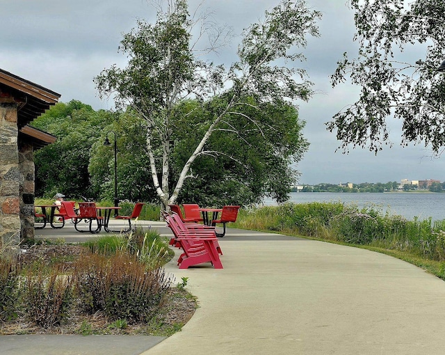 view of community with a water view and a patio area