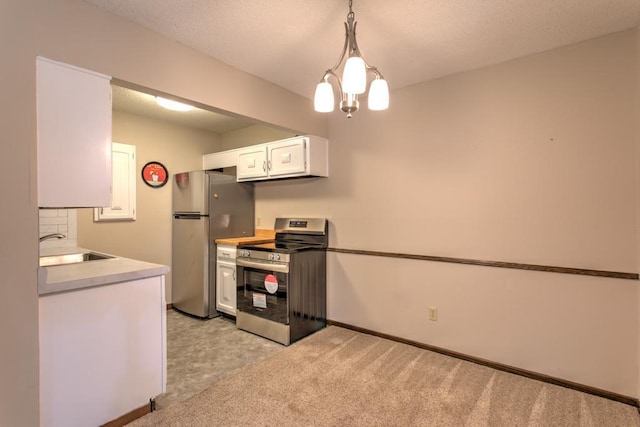 kitchen with white cabinetry, light colored carpet, appliances with stainless steel finishes, hanging light fixtures, and sink