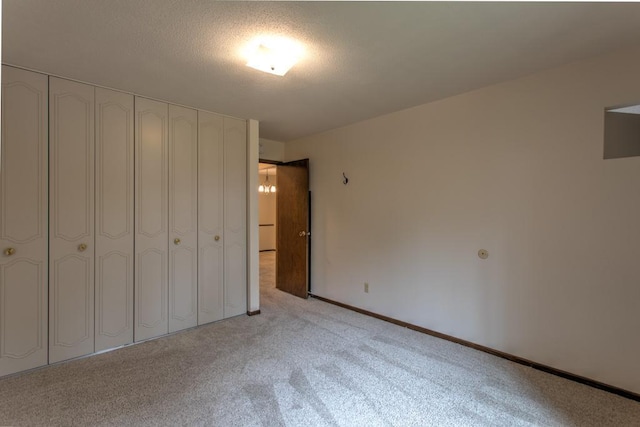 unfurnished bedroom with light carpet and a closet