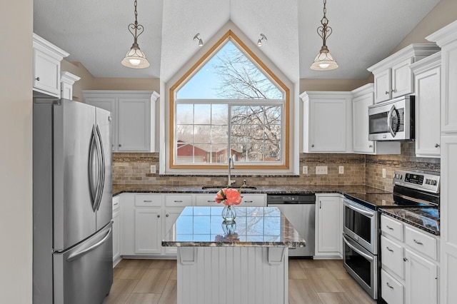 kitchen featuring white cabinetry, pendant lighting, stainless steel appliances, and a sink