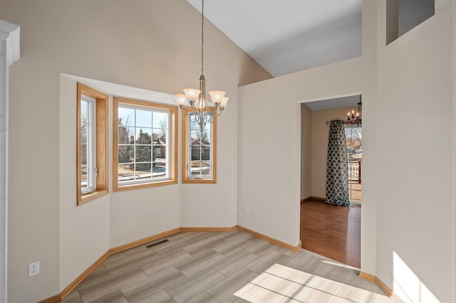 unfurnished dining area with a chandelier, wood finish floors, visible vents, and baseboards