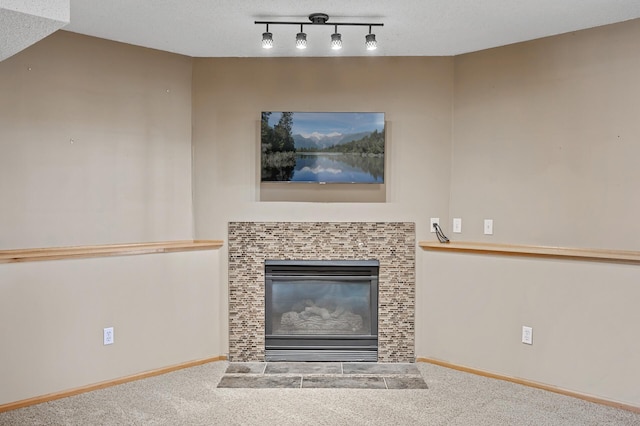 unfurnished living room featuring carpet floors, a fireplace, a textured ceiling, and baseboards