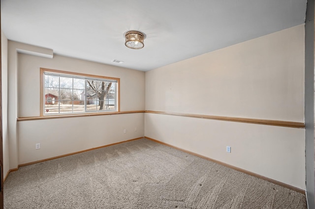 carpeted spare room featuring visible vents and baseboards