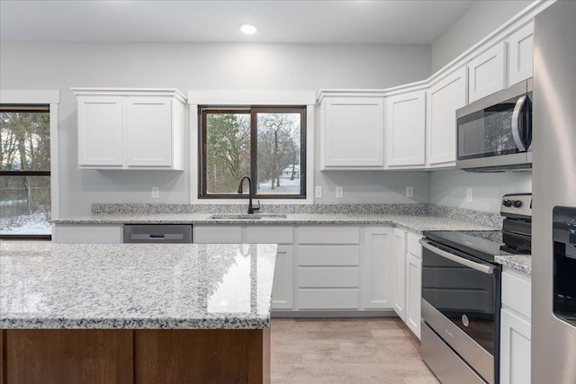 kitchen with light hardwood / wood-style floors, sink, white cabinetry, and stainless steel appliances