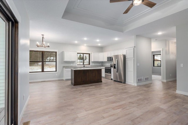 kitchen featuring a kitchen island, appliances with stainless steel finishes, and light hardwood / wood-style flooring