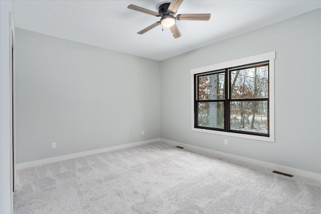 carpeted spare room with ceiling fan