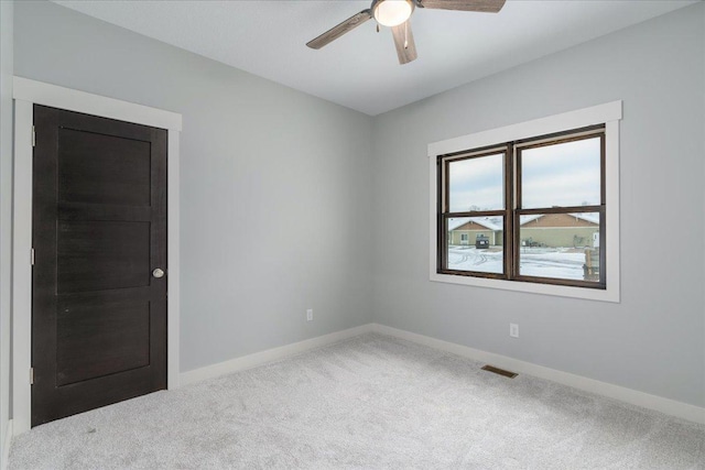 carpeted spare room featuring ceiling fan