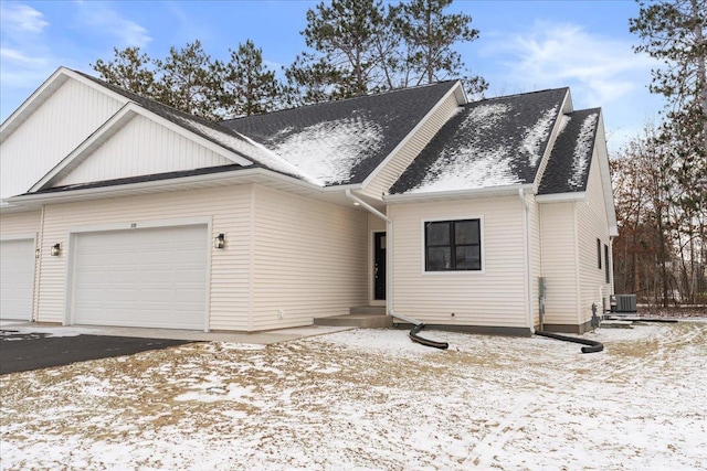 view of front of property featuring central AC and a garage