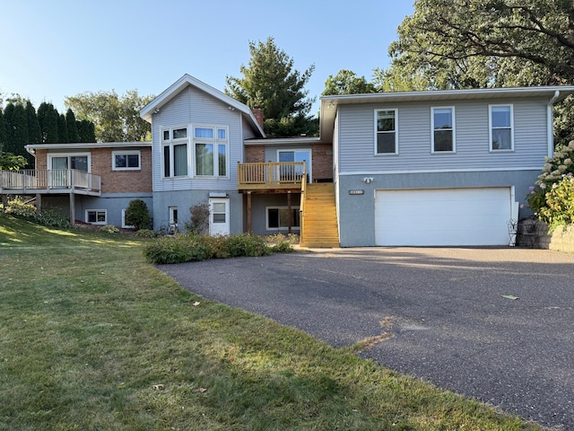 view of front of property featuring a garage, a wooden deck, and a front yard