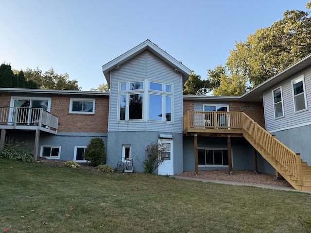 rear view of property with a lawn and a deck