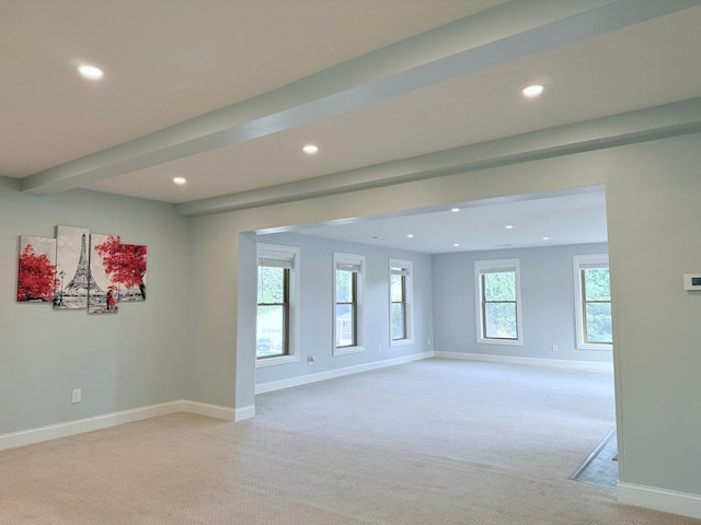 carpeted spare room with beam ceiling