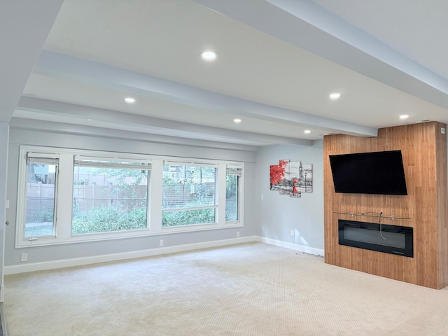 unfurnished living room featuring beamed ceiling, a fireplace, and carpet flooring