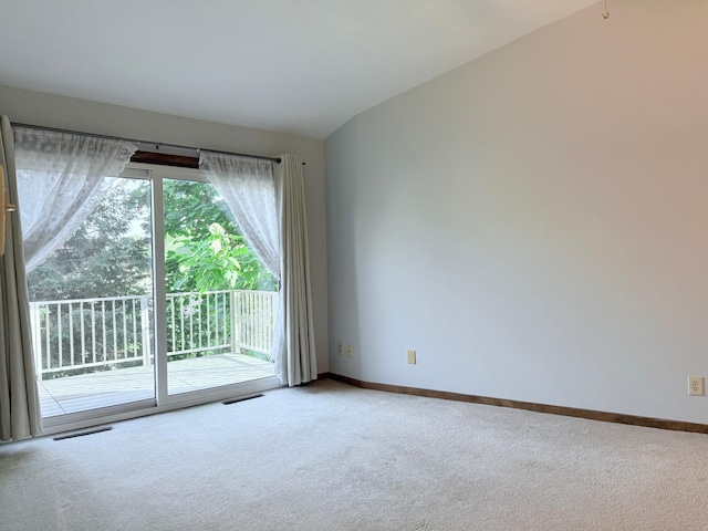 carpeted spare room featuring lofted ceiling