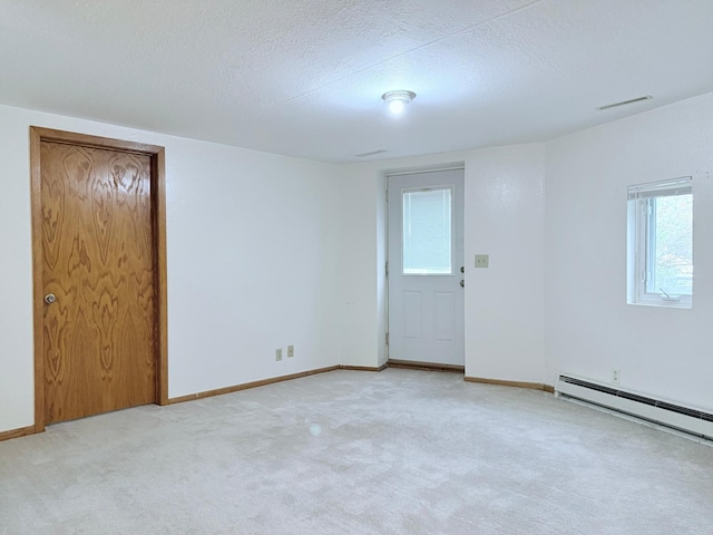 carpeted spare room featuring a baseboard radiator, a textured ceiling, and a healthy amount of sunlight