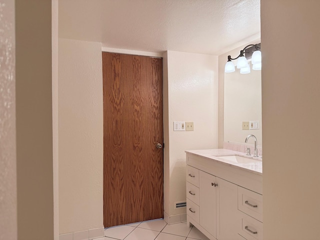 bathroom featuring a textured ceiling, vanity, and tile patterned floors