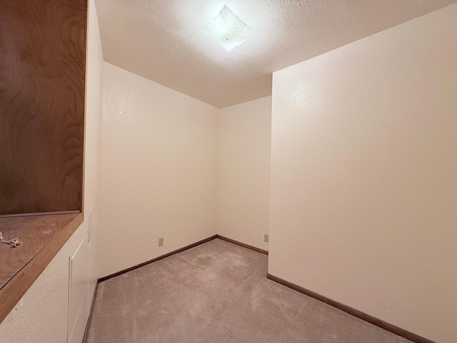 carpeted spare room featuring a textured ceiling