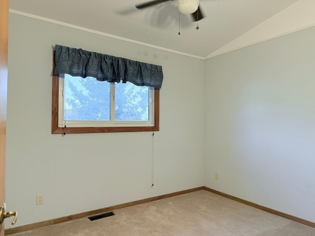 spare room featuring ornamental molding, vaulted ceiling, ceiling fan, and light carpet