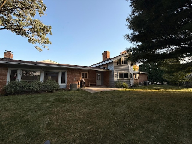 exterior space with cooling unit, a lawn, and a patio area