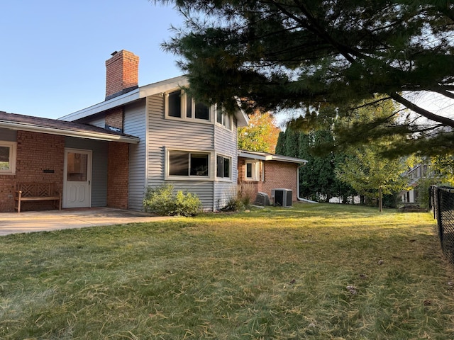 view of property exterior with a patio, central AC unit, and a yard