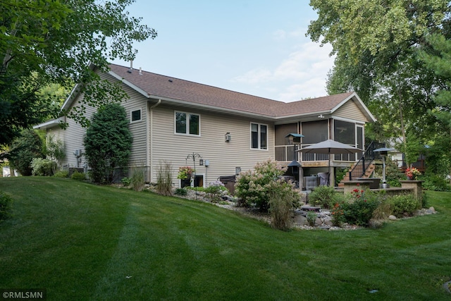 rear view of property with a deck and a lawn