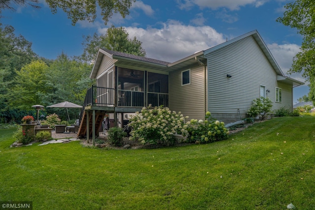 rear view of house with a sunroom and a yard