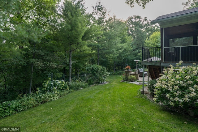 view of yard with a sunroom and a deck