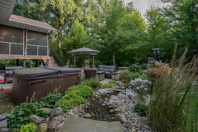 view of yard with a sunroom, a hot tub, an outdoor living space, and a patio area