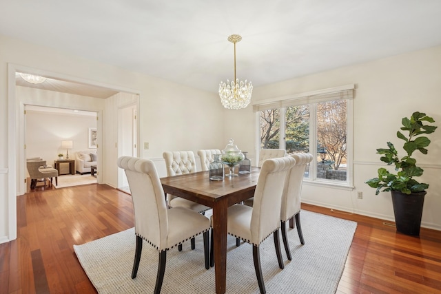 dining space featuring hardwood / wood-style flooring and a chandelier