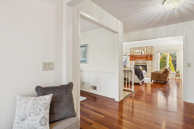 living area featuring dark wood-type flooring and a large fireplace