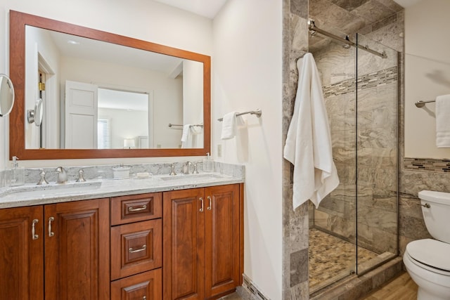 bathroom with vanity, toilet, tile walls, and walk in shower